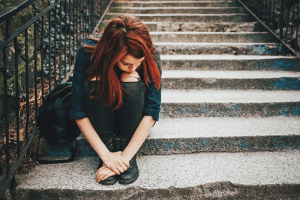 A sad girl sitting on the stairs mental health